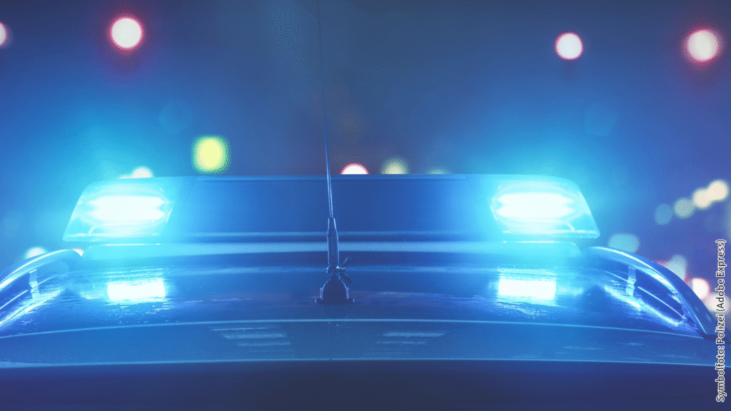 Blaulicht auf Polizeiauto bei Nacht, unscharfe Lichter im Hintergrund. Einsatzfahrzeug in Aktion.