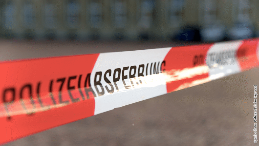 Polizeiabsperrband vor unscharfem Hintergrund, Symbolbild für Polizeiarbeit und Sicherheitsmaßnahme in Notfällen.