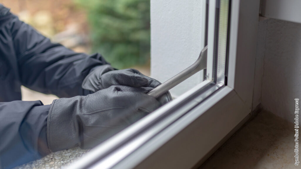 Einbrecher mit Brecheisen versucht, ein Fenster gewaltsam zu öffnen. Sicherheitsrisiko durch Einbruch einschätzen.