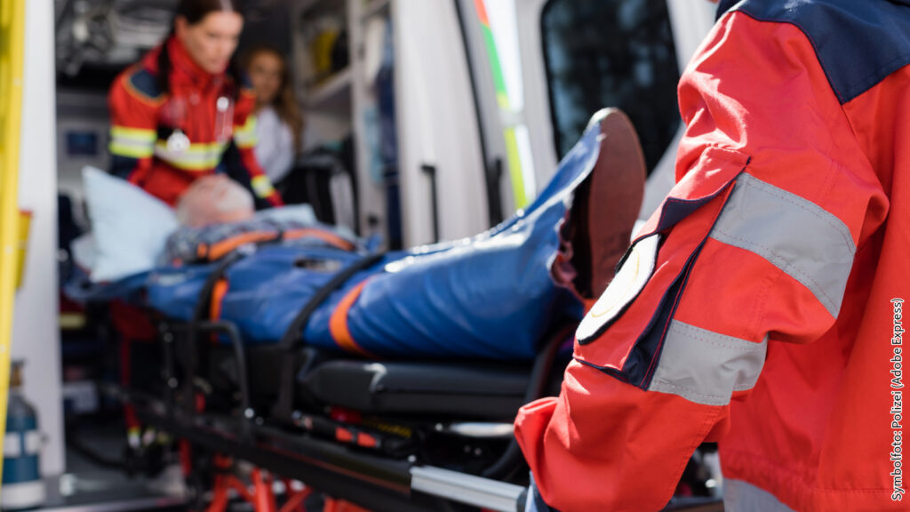 Rettungskräfte behandeln Patienten im Krankenwagen, fokussiert auf Pflege und medizinische Hilfe in Notfällen.