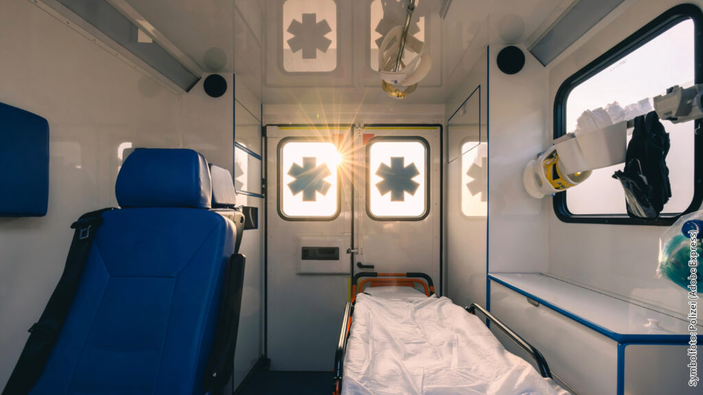 Innenansicht eines modernen Krankenwagens mit Trage bei Sonnenuntergang, medizinische Ausrüstung sichtbar.