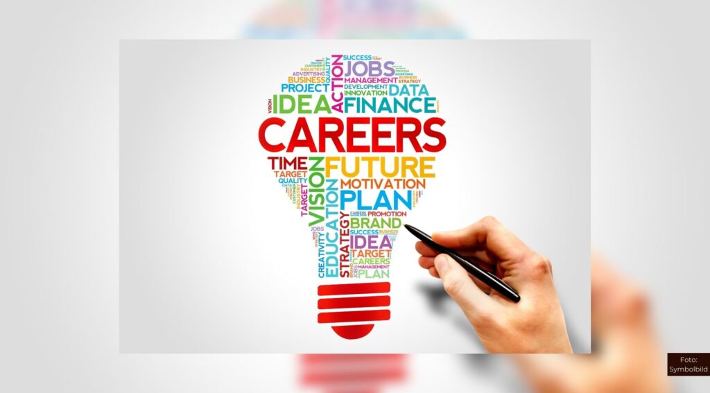 Bunte Karriere-Wortwolke in Glühbirnenform, eine Hand zeichnet mit einem Stift, symbolisiert kreative Berufsmöglichkeiten.