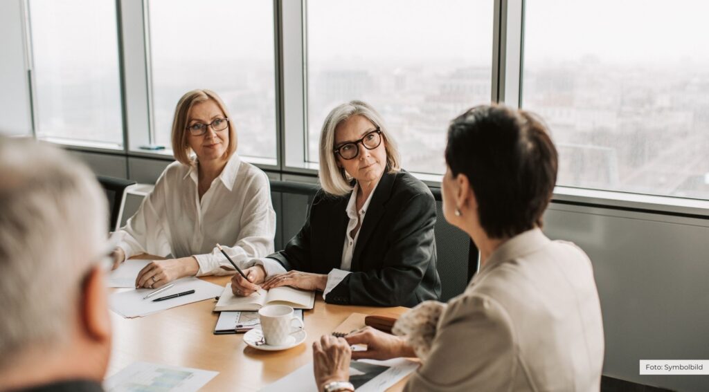 Symbolbild: Frauen in einem Konferenzraum im Gespräch über familienfreundliche Arbeitsbedingungen