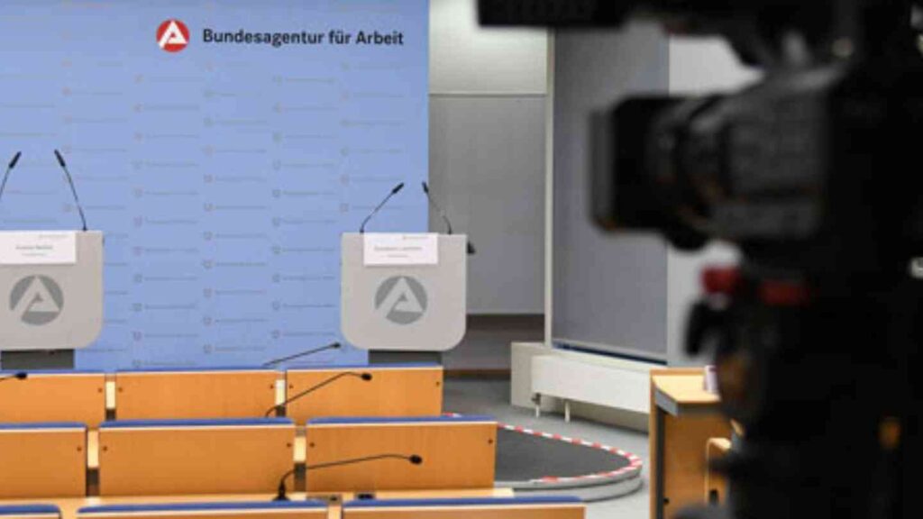 Pressekonferenzraum der Bundesagentur für Arbeit mit zwei Rednerpulten, leeren Sitzreihen und Kamera im Vordergrund