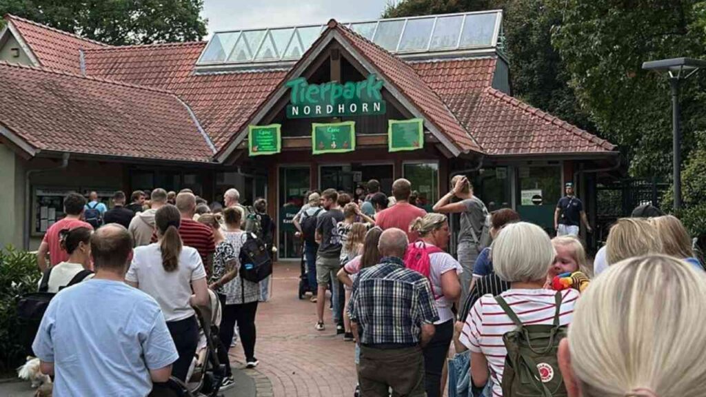 Menschenmenge am Eingang des Tierparks Nordhorn an einem sonnigen Tag, Besucher warten auf Einlass.