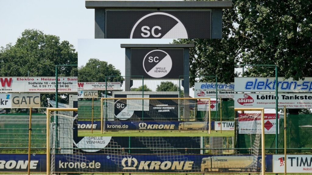 Fußballstadion mit SC Spelle Venhaus Logo und Werbebannern im Hintergrund, grüne Umgebung, sonniger Tag.
