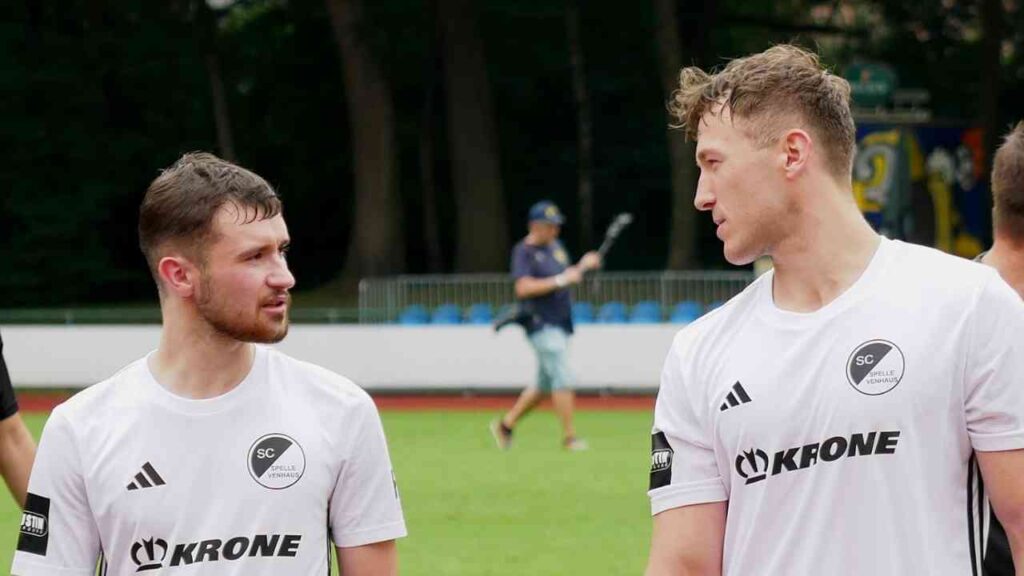 Zwei Fußballspieler im Gespräch auf dem Spielfeld im weißen Trikot des SC Spelle Venhaus.