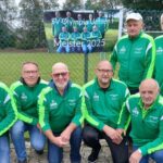 Senioren-Fußballteam des SV Olympia Uelsen feiert Meisterschaft 2025 in grüner Vereinskleidung vor Banner.