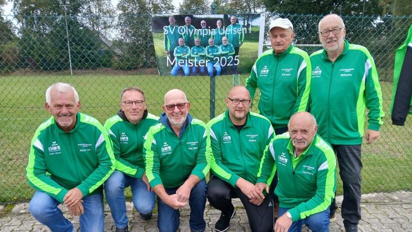 Senioren-Fußballteam des SV Olympia Uelsen feiert Meisterschaft 2025 in grüner Vereinskleidung vor Banner.