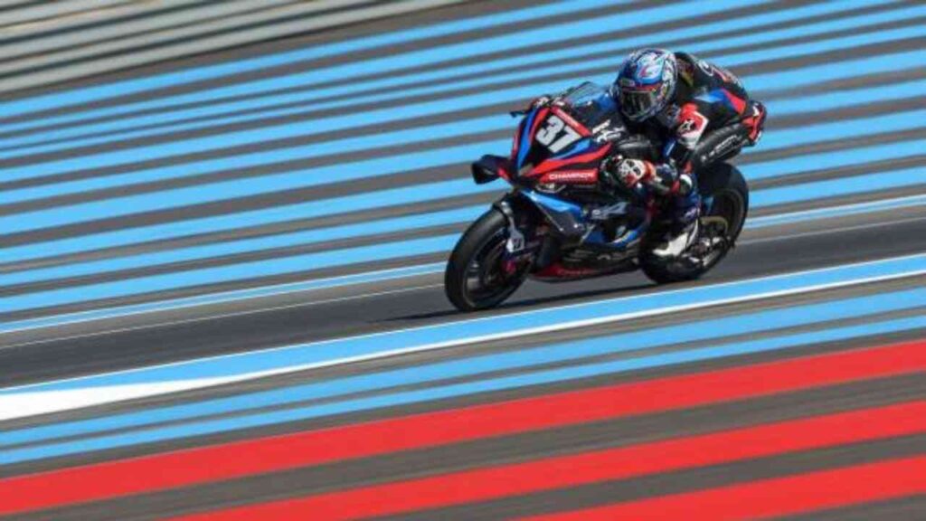 Motorradrennfahrer in Aktion auf gestreifter Rennstrecke, blau-rote Streifen, Geschwindigkeit und Dynamik, Motorsport.