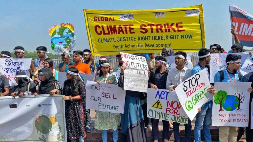 Junge Menschen protestieren beim globalen Klimastreik für Klimagerechtigkeit mit Bannern und Schildern.