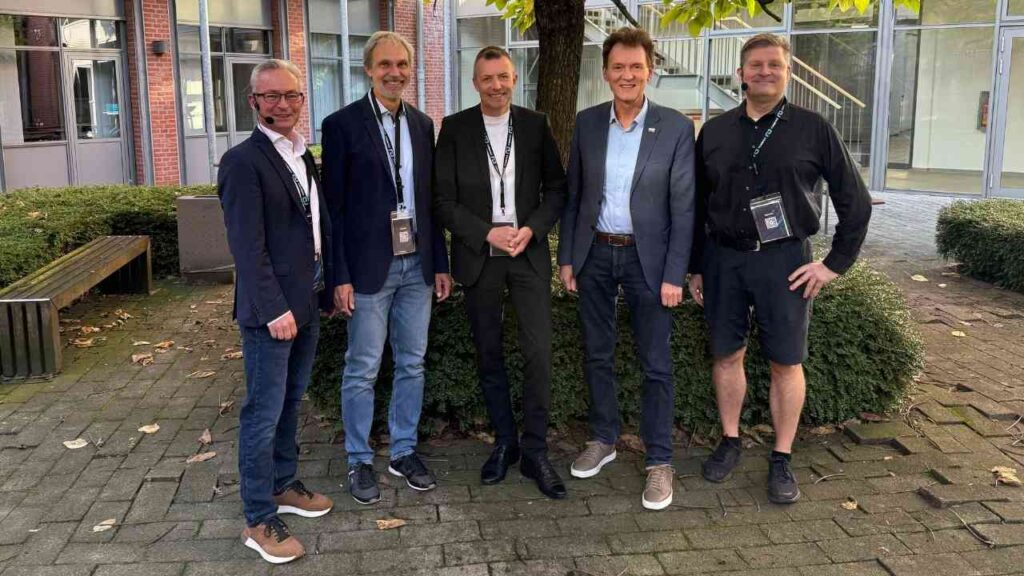 Gruppe von fünf Männern in Business-Kleidung im Freien stehend, Herbstlich, Unterschriften-Event.