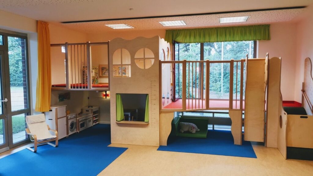 Indoor-Spielplatz mit Holz-Klettergerüst und Küche, ideal für Kinder zum Spielen und Entdecken.
