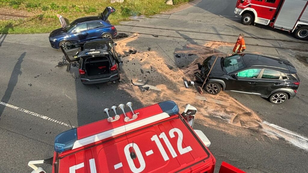 Verkehrsunfall mit drei Autos, Feuerwehr im Einsatz, Schadensaufnahme und Reinigung der Unfallstelle auf der Straße.