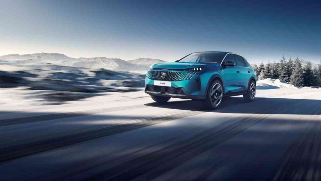 Blauer PEUGEOT E-3008 fährt auf verschneiter Straße mit Bergen im Hintergrund. Ideal für winterliche Landschaften.