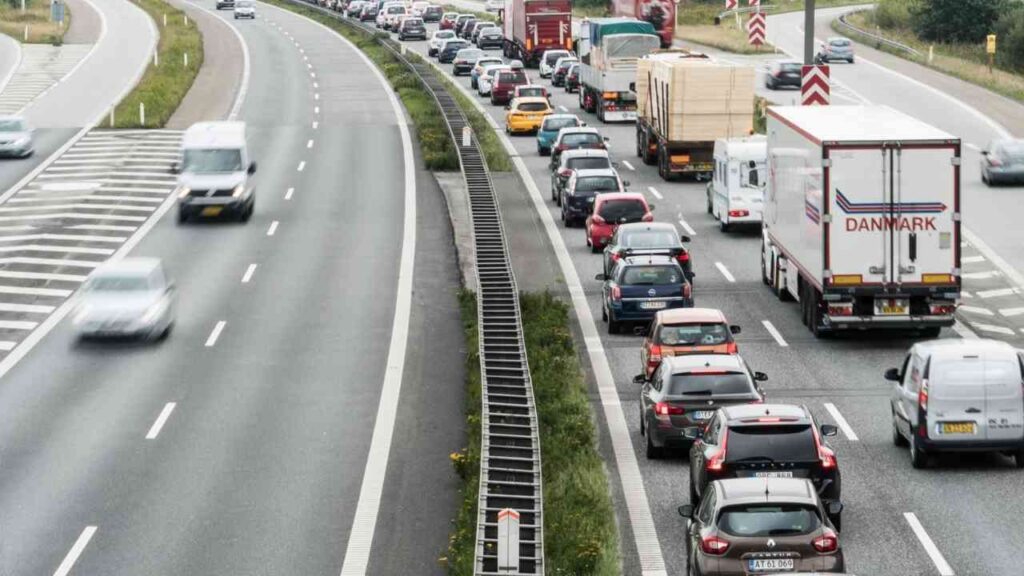 Stau auf Autobahn: Hohe Fahrzeugzahl auf rechter Spur, linke Spur frei. Verkehrsüberlastung in urbanem Gebiet.