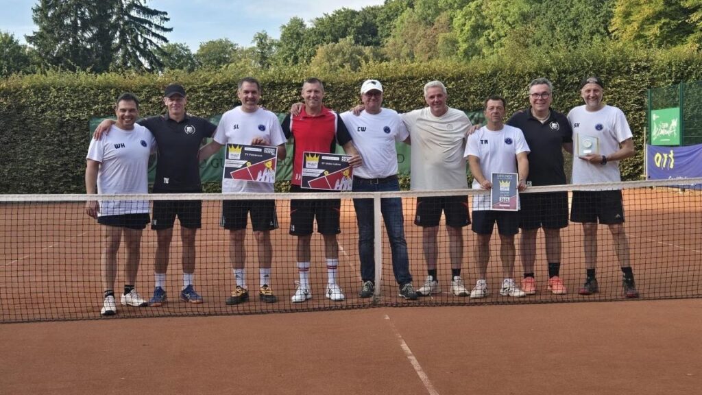 Gruppe von Tennisspielern auf dem Platz nach einem Turniersieg mit Urkunden und Trophäe, glückliche Gesichter.