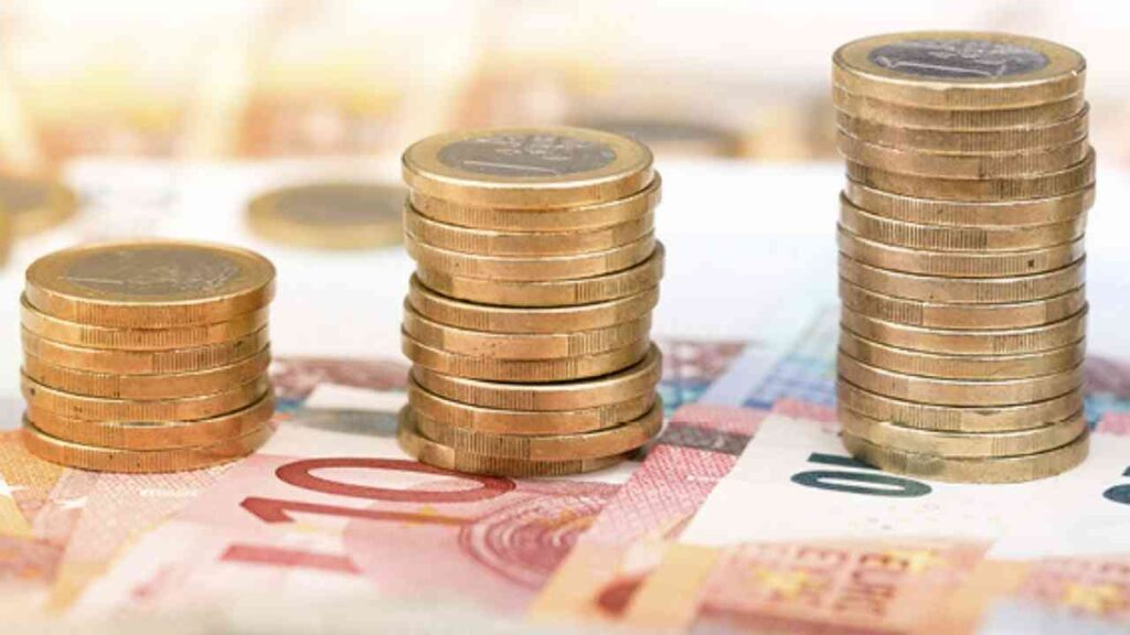 Gestapelte Euro-Münzen auf Euroscheinen, symbolisieren finanzielles Wachstum und Sparen.