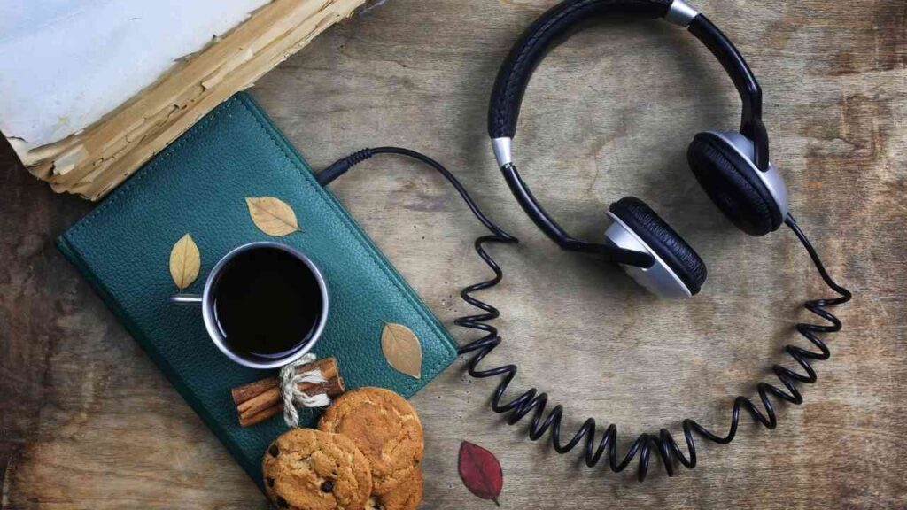 Tasse Kaffee, Kekse, Kopfhörer und Notizbuch auf Holzoberfläche. Entspannt lesen und Musik hören. Perfekte Kaffeepause.