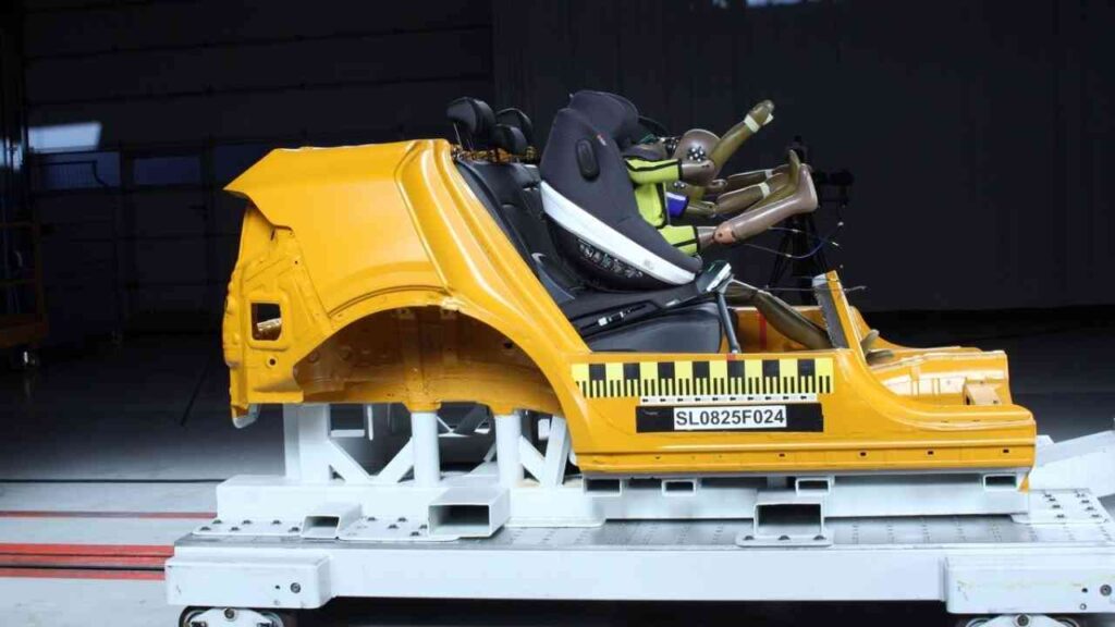 Gelber Autositze-Testaufbau mit Sicherheitskomponenten und Crash-Test-Dummys auf einer Testplattform.