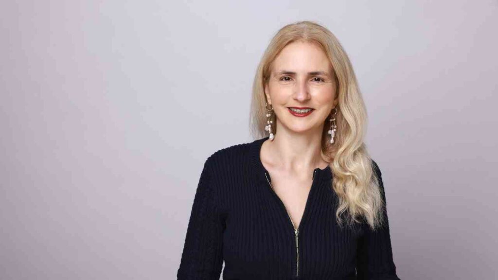 Ayse Mese, Geschäftsführerin der Hamburg JDB Holding und DUP Media GmbH, mit blonden Haaren und Ohrringen.