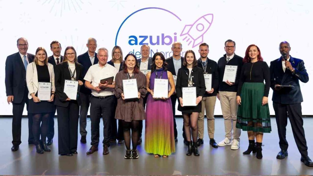 Gruppe von Personen, die bei der Verleihung der Azubi des Nordens 2025 auf einer Bühne posieren.