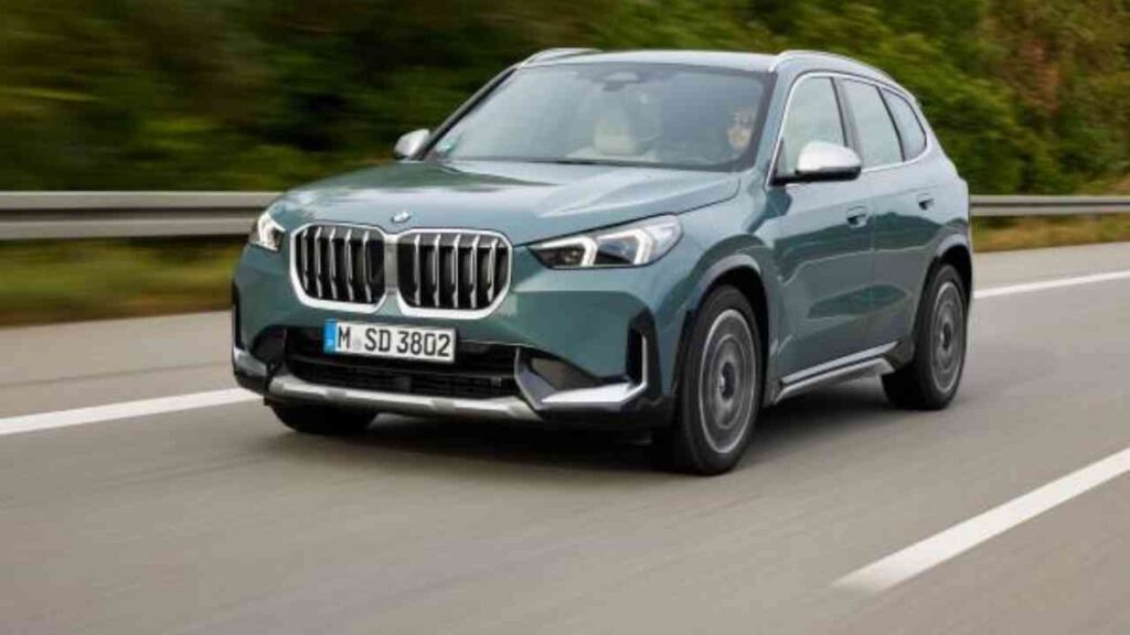 BMW SUV in einer dynamischen Fahrposition auf einer Straße mit grüner Umgebung.