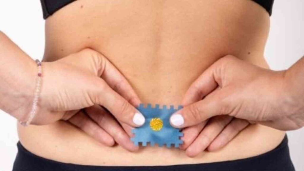 Eine Person, die ein therapeutisches Pflaster auf den unteren Rücken aufträgt, um Schmerzen zu lindern.