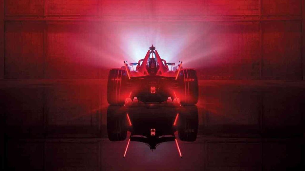 Formel E-Rennwagen mit leuchtenden roten Lichtern, von hinten betrachtet in einer dunklen Umgebung.