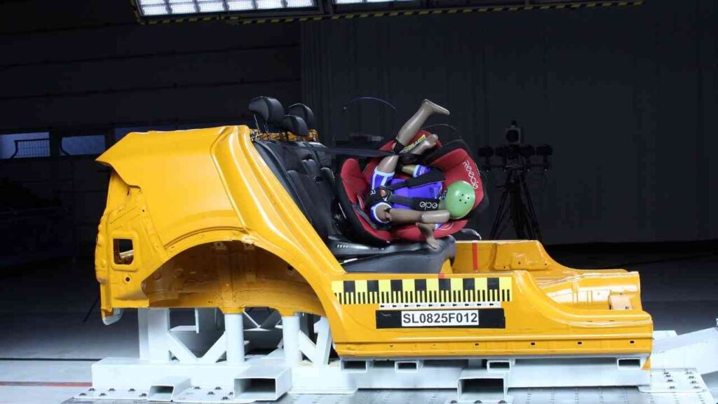 Auto-Crash-Test mit Dummypuppe im Kindersitz zeigt Sicherheitsaspekte bei Frontalaufprall.
