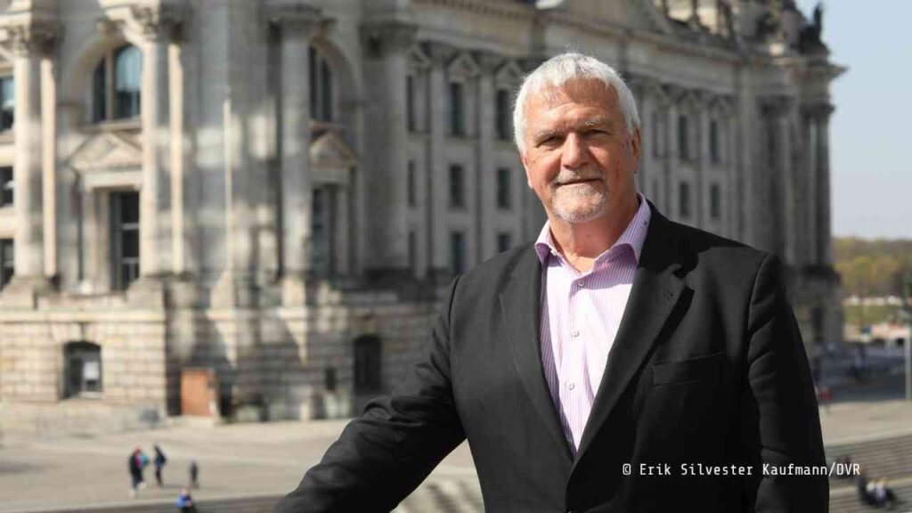 Manfred Wirsch, Präsident der DVR, posiert vor einem historischen Gebäude in Berlin.