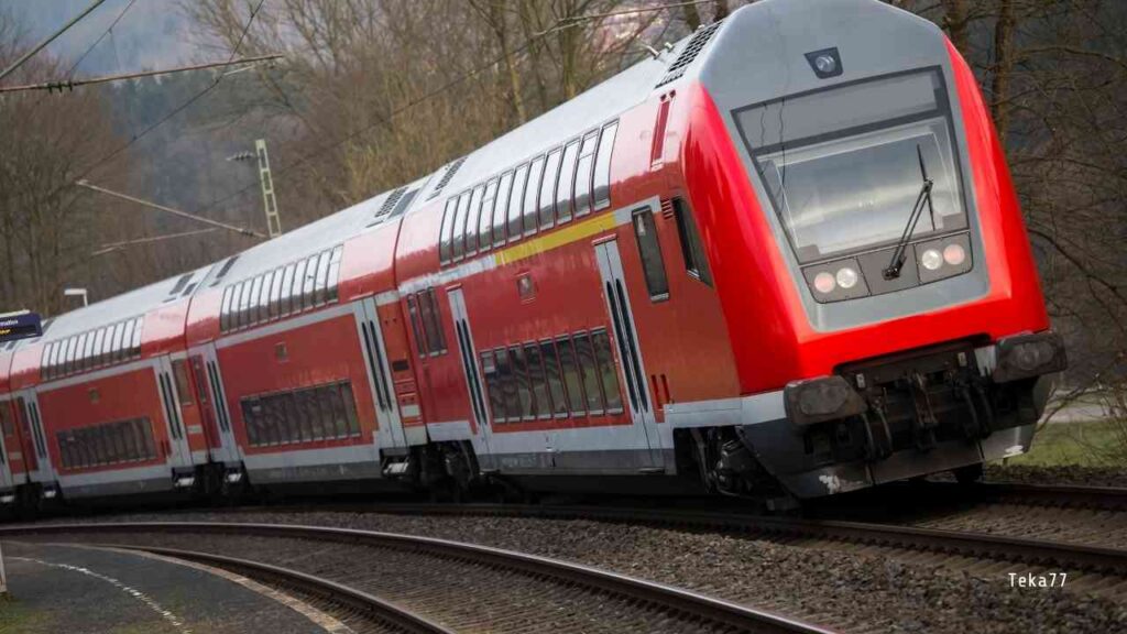Zug der Deutschen Bahn mit rotem Design fährt auf einer kurvenreichen Strecke.