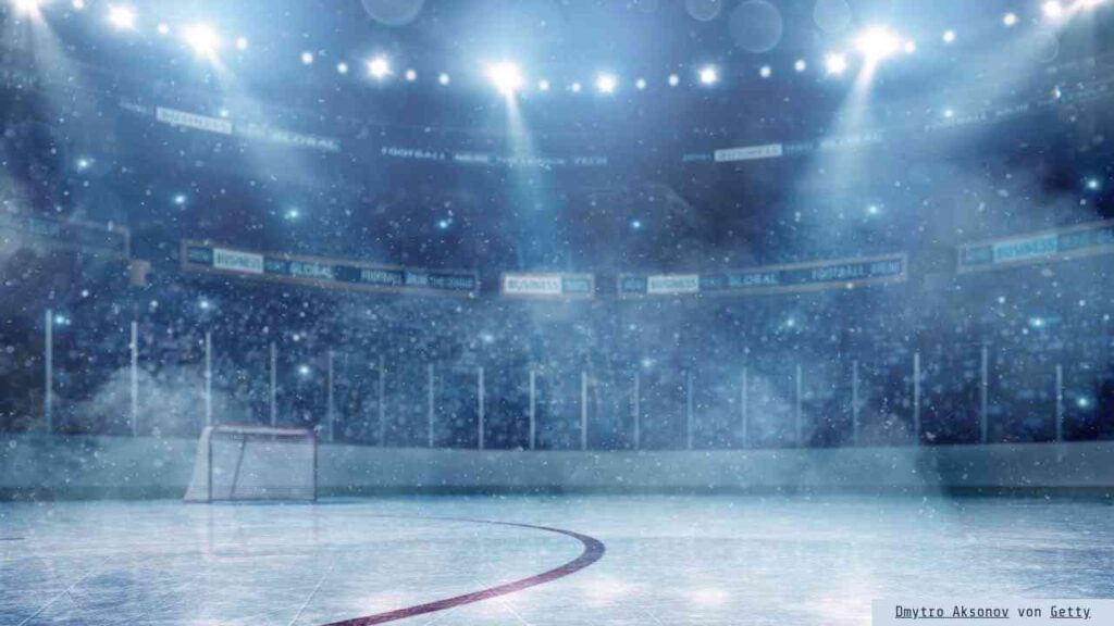 Eisfläche in einer Eishalle mit Tor und Lichtern, die eine sportliche Atmosphäre schaffen.