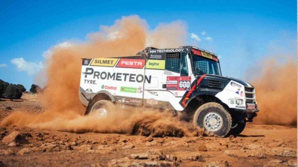 Rallye-Raid-Truck mit Prometeon-Reifen, der durch eine staubige Landschaft fährt.