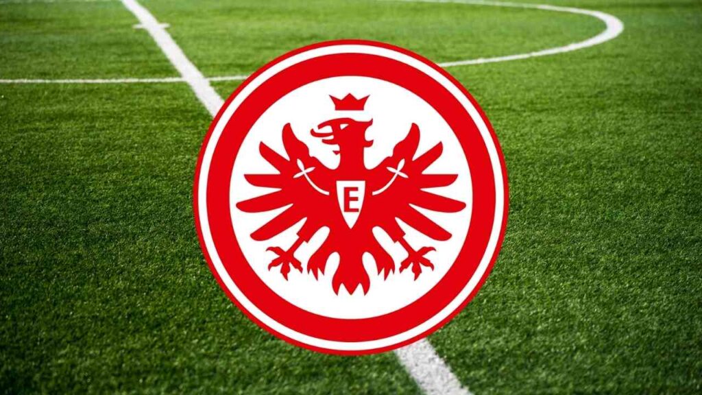 Das Logo von Eintracht Frankfurt, einem deutschen Fußballverein, auf einem grünen Rasenfeld.