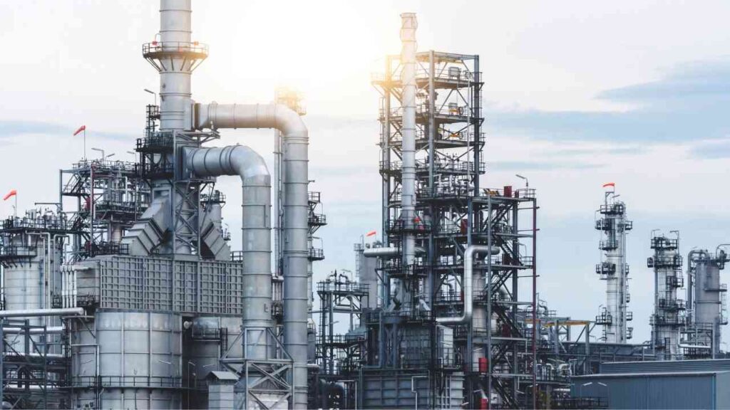 Industrielle Raffinerie mit großen Rohren und Türmen unter einem bewölkten Himmel.