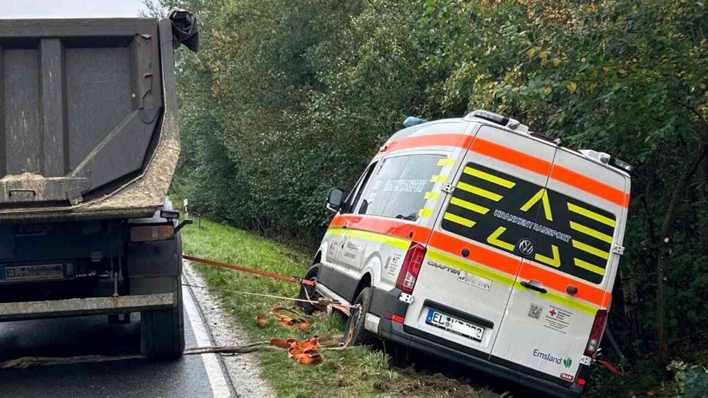 Ein Rettungswagen, der von der Straße abgekommen ist und an einem Lkw befestigt ist.
