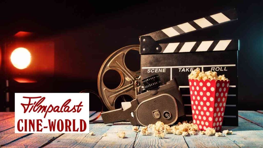 Filmklappe, Filmprojektor und eine Tüte Popcorn auf einem Tisch.