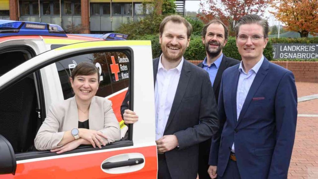 Vier Personen stehen neben einem Rettungsfahrzeug des Deutschen Roten Kreuzes in Osnabrück.
