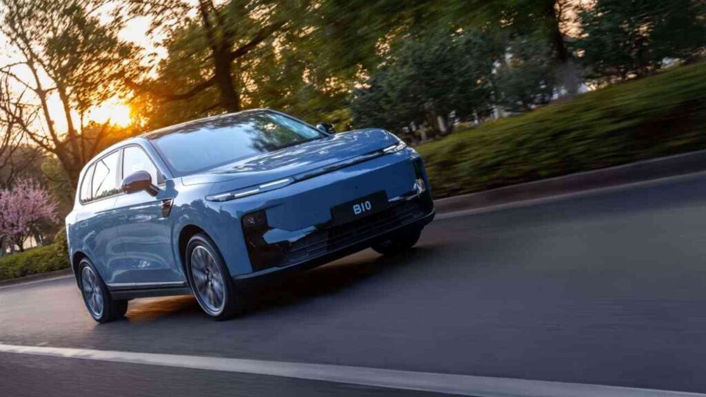 Blaues Elektroauto bei Sonnenuntergang auf der Straße, umgeben von Bäumen, modernes Design.