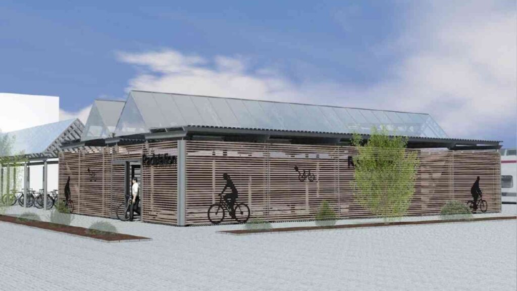 Moderne Radstation am Papenburger Bahnhof mit Holzverkleidung und Glasdach, Fahrradabstellplätzen im Vordergrund.