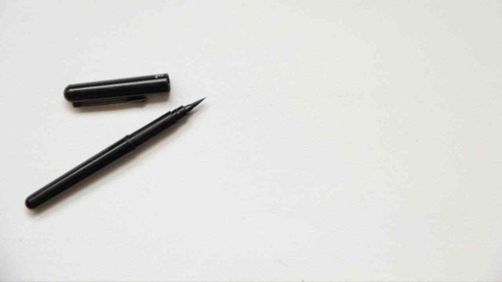 Schwarzer Füllfederhalter mit abgenommenem Deckel auf einem weißen Hintergrund.