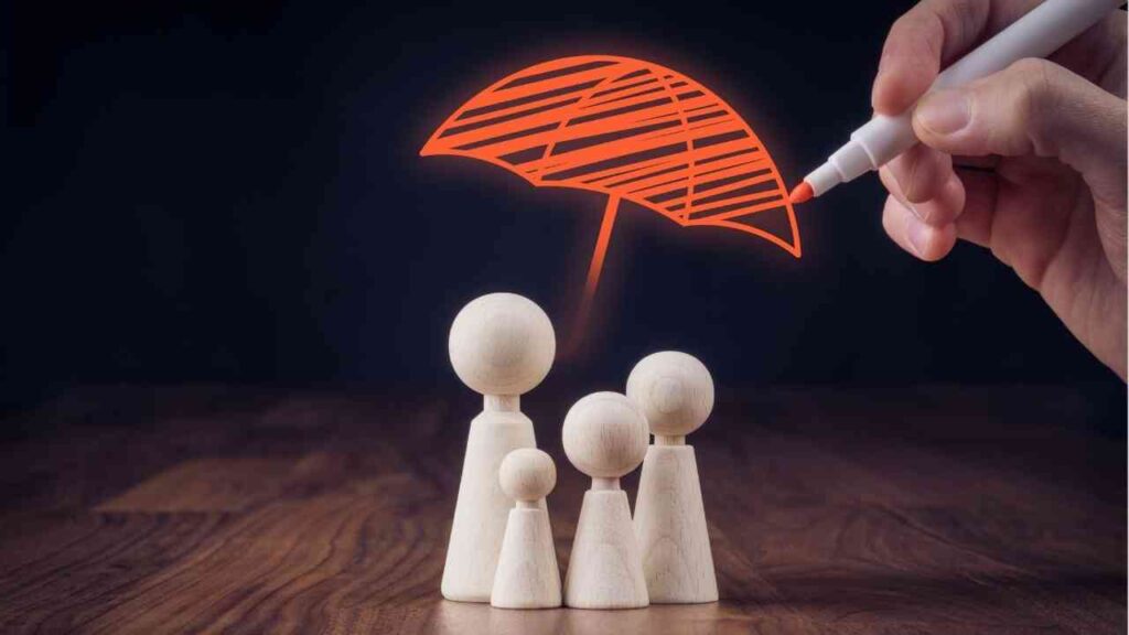 Holzfiguren einer Familie mit einem gezeichneten roten Regenschirm darüber, der Schutz symbolisiert.