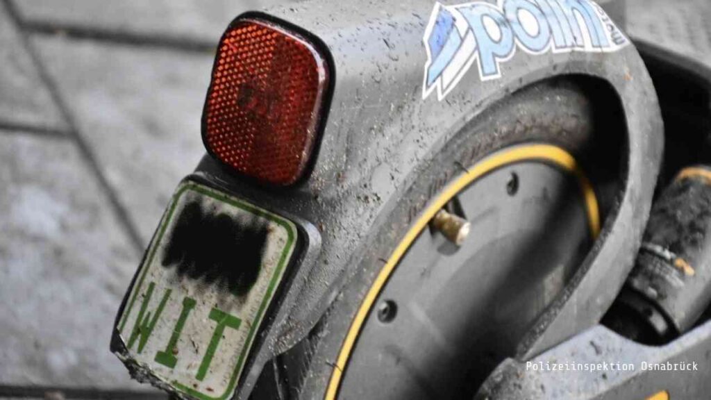 Nahaufnahme eines schmutzigen E-Scooters mit abgedunkeltem Nummernschild und Rücklicht.