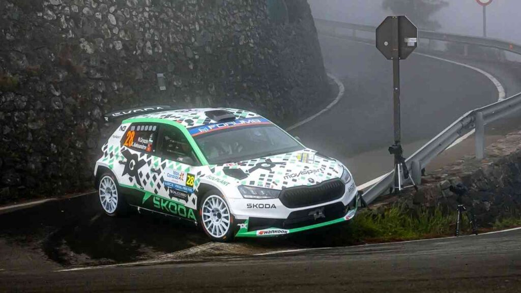 Skoda Fabia RS Rally2, ein Rallye-Auto, das an einer Kurve auf einer Straße steht, umgeben von Nebel.