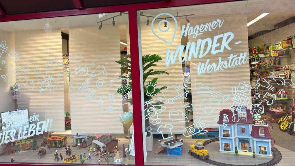 Schaufenster der Hagener Wunder-Werkstatt mit Spielzeug und kreativen Elementen in einer bunten Präsentation.