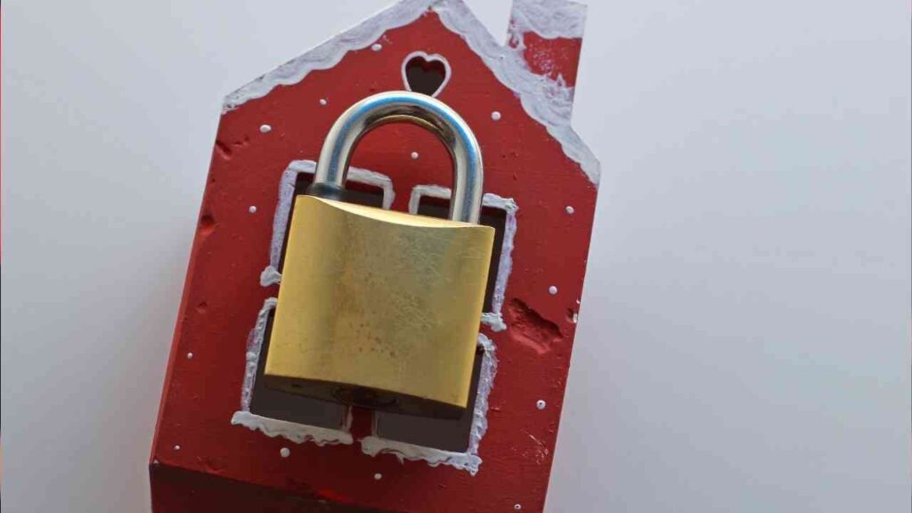 Roter Hausanhänger mit einem goldenen Vorhängeschloss, das auf der Vorderseite angebracht ist.