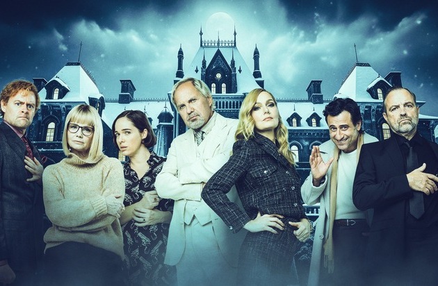 Schauspieler in formeller Kleidung vor einem historischen Gebäude in einer dramatischen Szenerie.