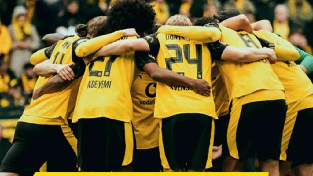 Spieler des FC Bayern München in gelben Trikots umarmen sich während eines Spiels in der Allianz Arena.