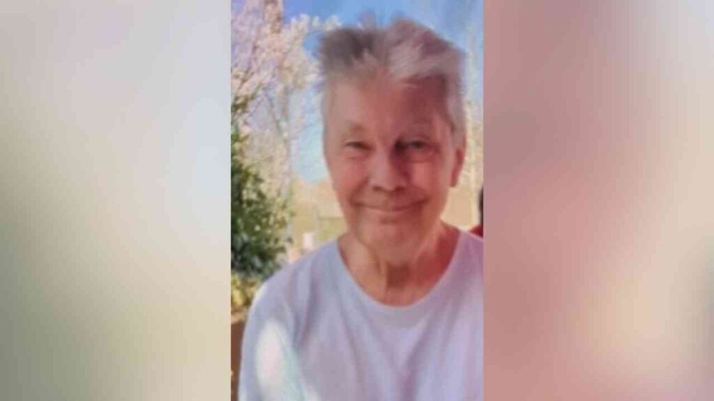 Ältere Frau mit grauen Haaren und freundlichem Lächeln, die in die Kamera schaut.